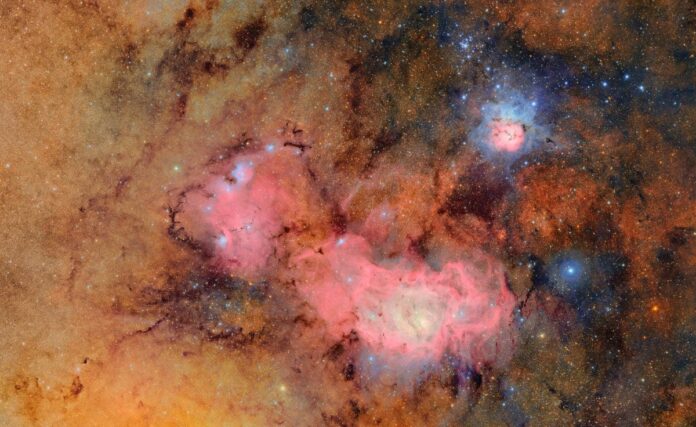 Gambar ini merupakan hasil penggabungan dari 678 foto terpisah yang diambil oleh Vera C. Rubin Observatory (yang didanai oleh NSF dan DOE) dalam waktu lebih dari tujuh jam pengamatan. Dengan menggabungkan banyak gambar seperti ini, detail yang biasanya samar atau tak terlihat menjadi jelas seperti awan gas dan debu yang membentuk Trifid Nebula (di atas) dan Lagoon Nebula, yang berjarak ribuan tahun cahaya dari Bumi. [astakom / NSF–DOE Vera C. Rubin Observatory]