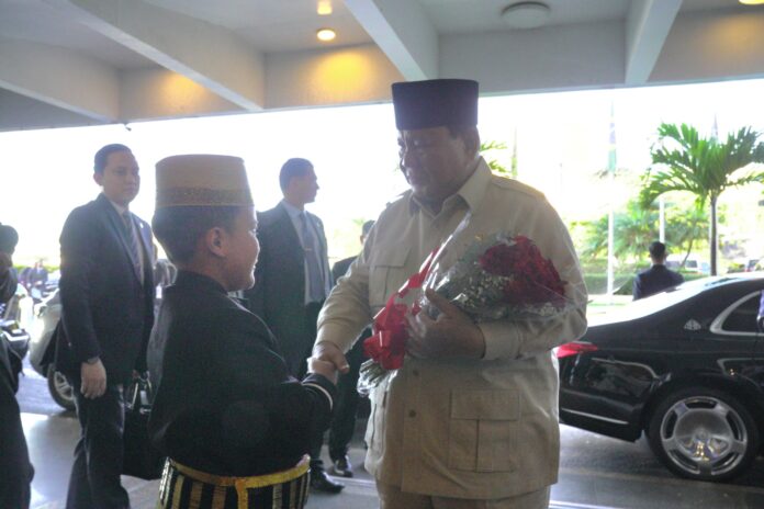 Presiden Prabowo menerima bunga dari salah satu Diaspora saat tiba di Brasil. [astakom / Tim Media Presiden]