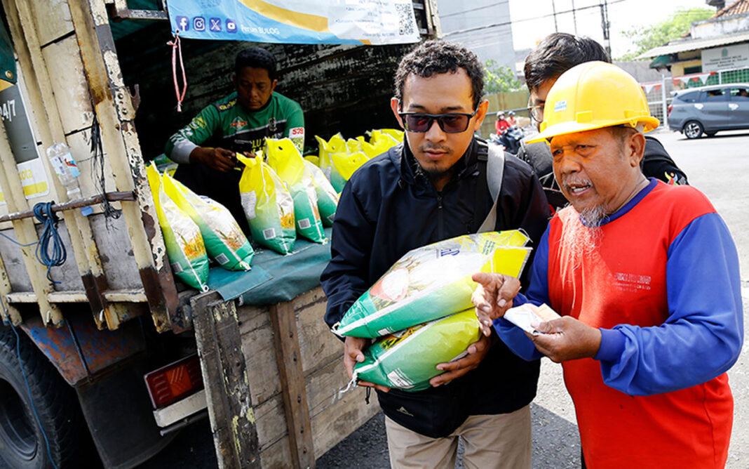 Sejumlah warga membeli beras Bulog, di Pasar Pacar Keling Surabaya, Sabtu (13/9).