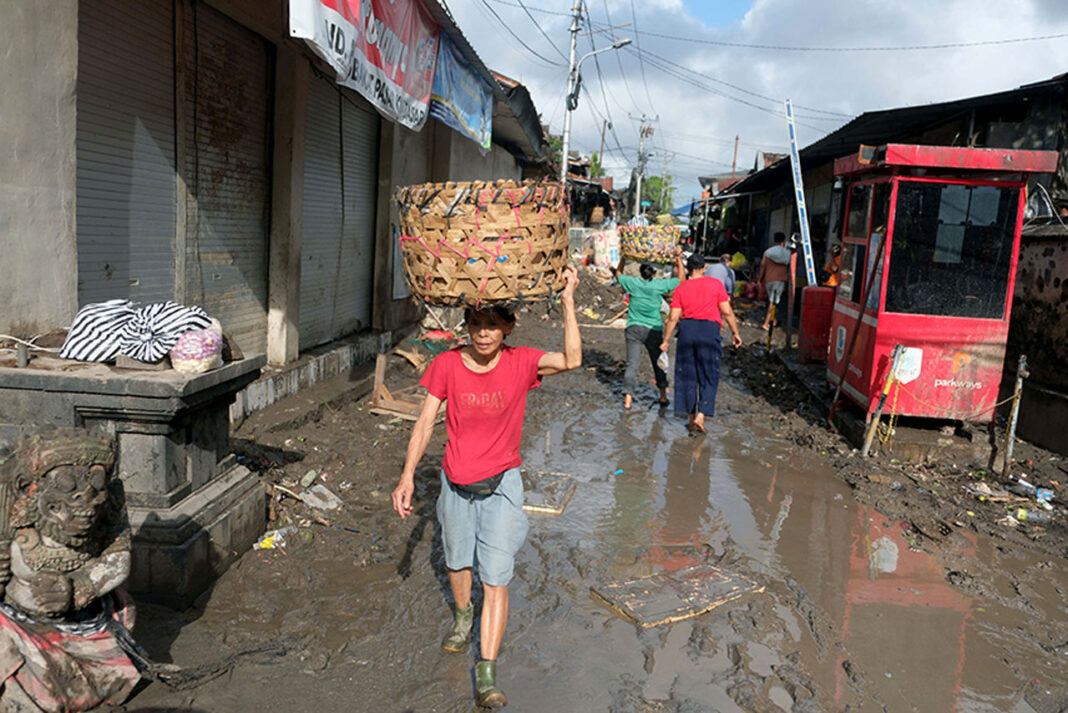 Tim Gabungan membersihkan lumpur dan material pascabanjir, di Denpasar, Bali, Kamis (11/9).