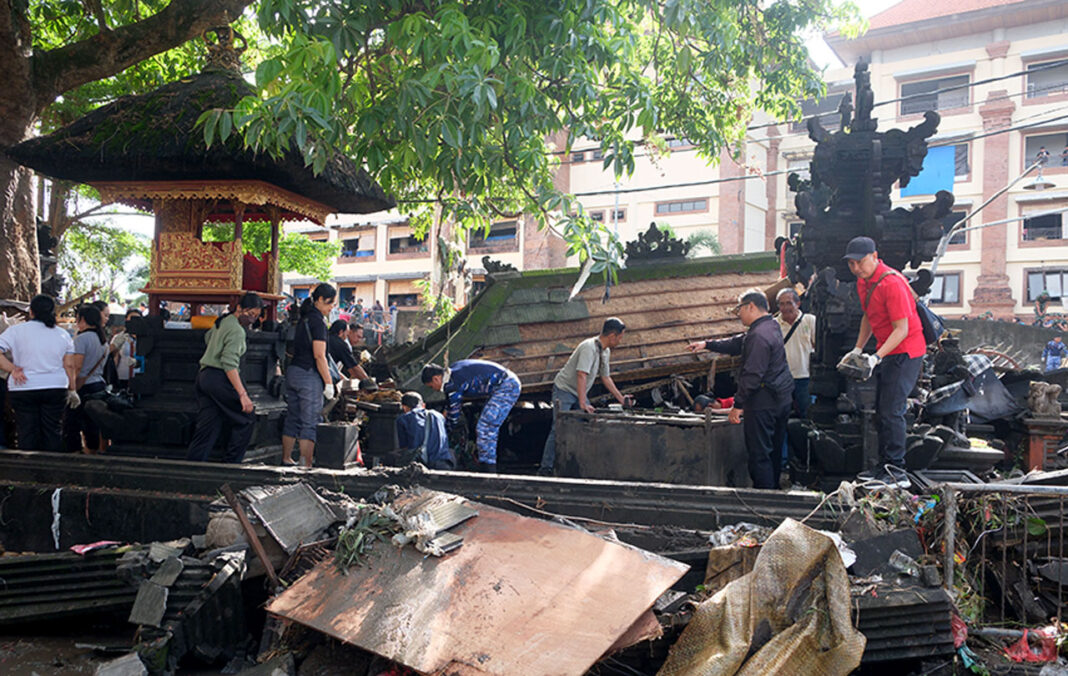 Tim Gabungan membersihkan lumpur dan material pascabanjir, di Denpasar, Bali, Kamis (11/9).