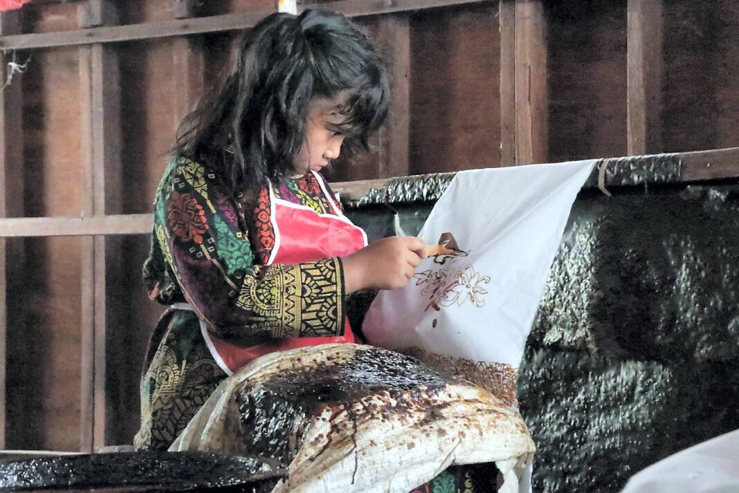 Murid TK Aceh Intercultural School belajar membatik menggunakan canting dalam peringatan Hari Batik Nasional di Rumoh Batik Aceh, kawasan Pagar Air, Kecamatan Ingin Jaya, Aceh Besar, Kamis (2/10).