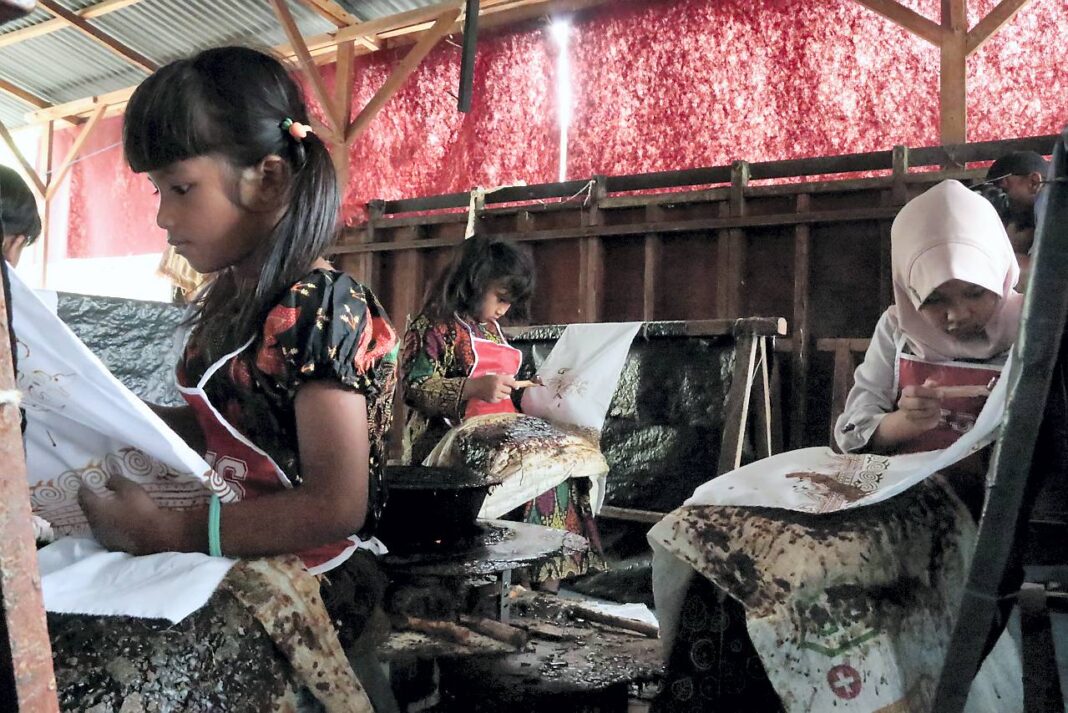 Murid TK Aceh Intercultural School belajar membatik menggunakan canting dalam peringatan Hari Batik Nasional di Rumoh Batik Aceh, kawasan Pagar Air, Kecamatan Ingin Jaya, Aceh Besar, Kamis (2/10).