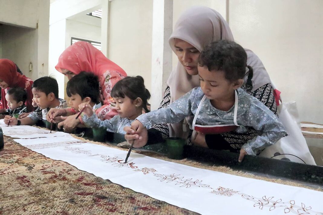 Murid TK Aceh Intercultural School belajar membatik menggunakan canting dalam peringatan Hari Batik Nasional di Rumoh Batik Aceh, kawasan Pagar Air, Kecamatan Ingin Jaya, Aceh Besar, Kamis (2/10).