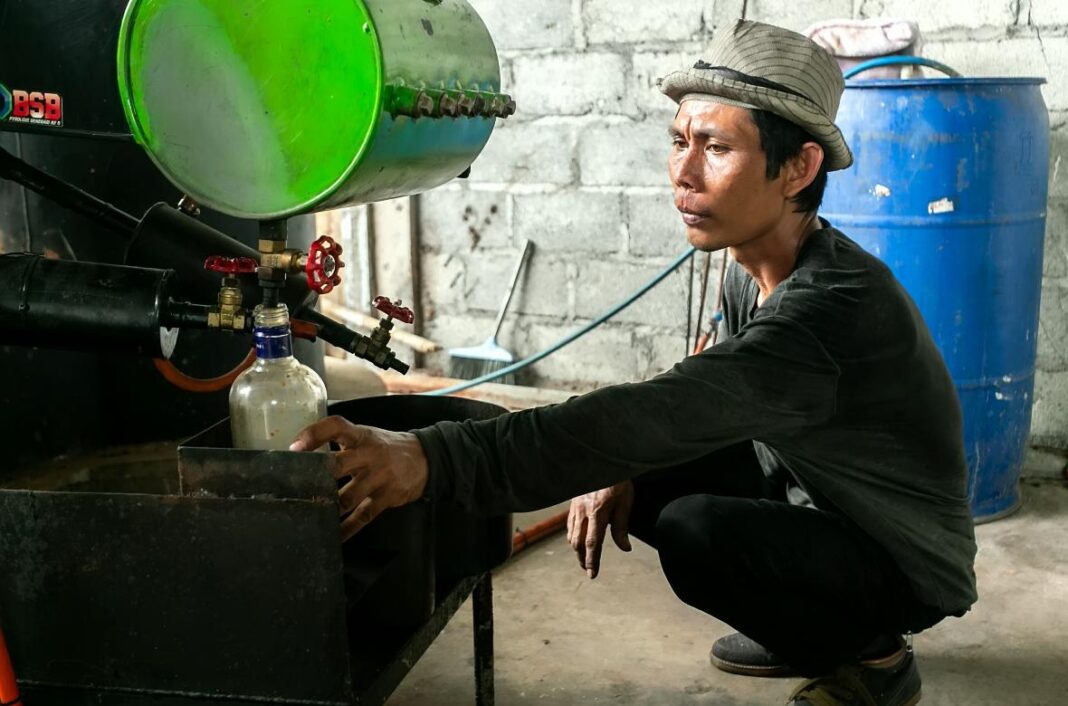 Pekerja dari Kelompok Usaha Pengelolaan Sampah (KUPAS) mengolah sampah plastik secara mandiri menjadi Bahan Bakar Minyak (BBM) sebagai inovasi ramah lingkungan di Tempat Pembuangan Sampah (TPS) Panggungharjo, Bantul, Yogyakarta, Sabtu (4/10).