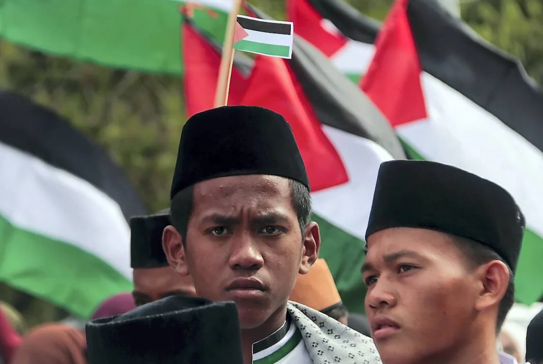 Masyarakat Banda Aceh yang tergabung dalam kelompok Masyarakat Aceh Peduli Palestina menggelar aksi di kawasan Car Free Day (CFD) Banda Aceh, Minggu (12/10).