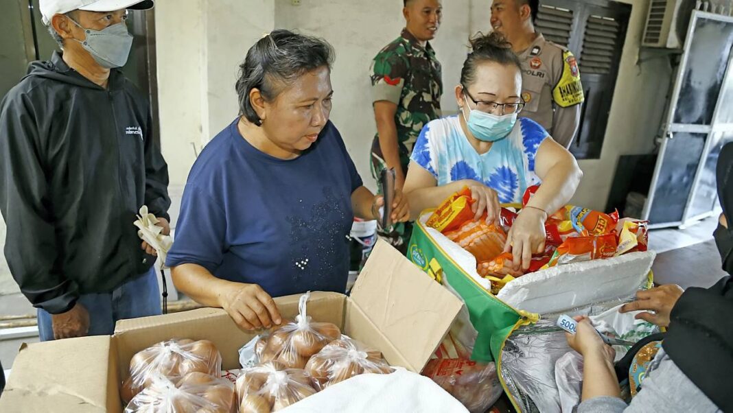 Sejumlah warga mengantre dan memilih sembako yang dijual dengan harga terjangkau sesuai Harga Eceran Tetap (HET), di Kelurahan Kupang Krajan Surabaya, Jawa Timur, Kamis (16/10).