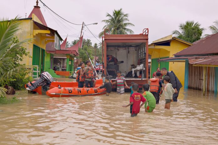 Warga melintasi baniir di Nagari Kampung Galapuang Ulakan, Kecamatan Ulakan Tapakis, Kabupaten Padang Pariaman, Sumatera Barat, Senin (24/11).