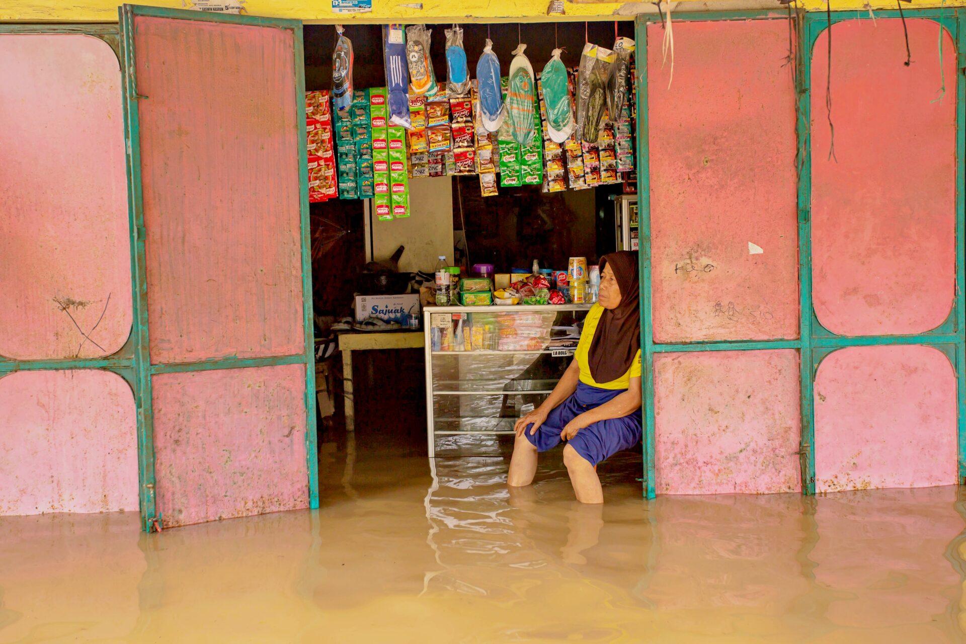 Warga melintasi banjir, di Nagari Kampung Galapuang Ulakan, Kecamatan Ulakan Tapakis, Kabupaten Padang Pariaman, Sumatera Barat, Senin (24/11).