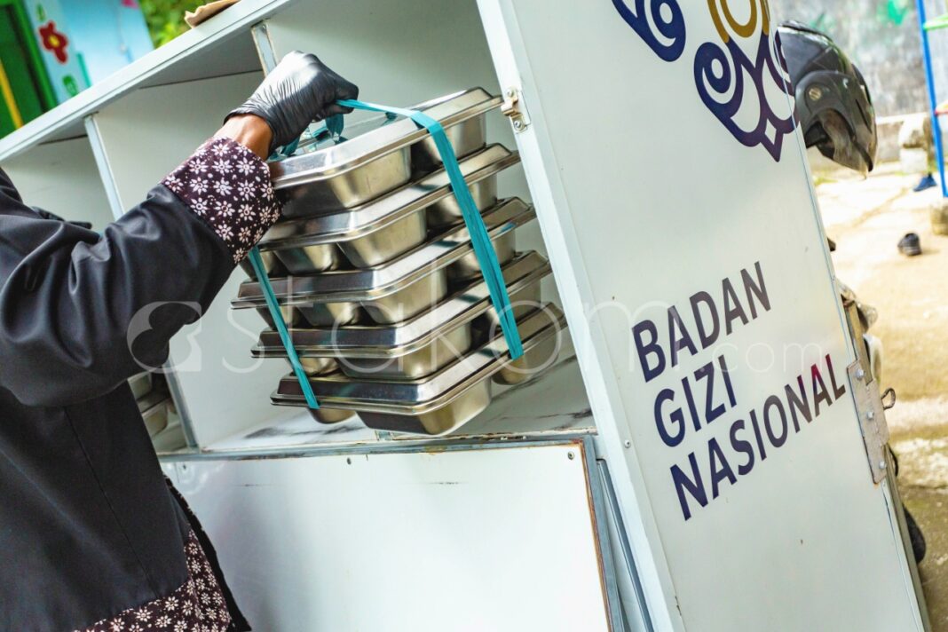 Satuan Pelayanan Pemenuhan Gizi (SPPG) Pengasih 1 mengendarai sepeda motor distribusi Makanan Bergizi Gratis (MBG) ke sekolah-sekolah, di Kulon Progo, Daerah Istimewa (DI) Yogyakarta, Senin (1/12).