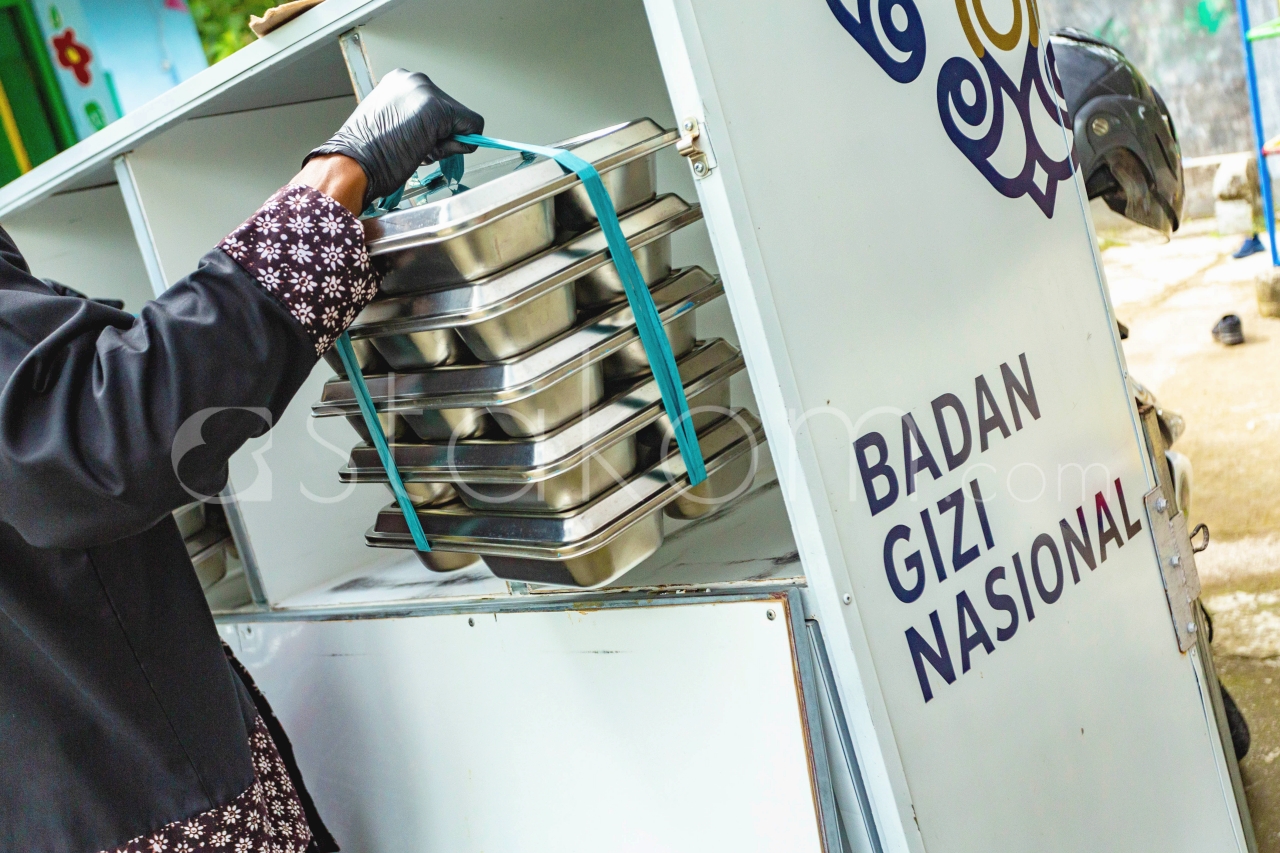 Satuan Pelayanan Pemenuhan Gizi (SPPG) Pengasih 1 mengendarai sepeda motor distribusi Makanan Bergizi Gratis (MBG) ke sekolah-sekolah, di Kulon Progo, Daerah Istimewa (DI) Yogyakarta, Senin (1/12).