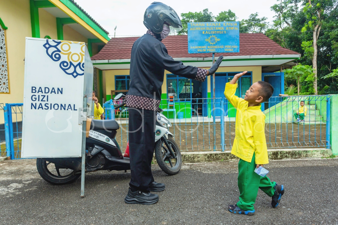 Satuan Pelayanan Pemenuhan Gizi (SPPG) Pengasih 1 mengendarai sepeda motor distribusi Makanan Bergizi Gratis (MBG) ke sekolah-sekolah, di Kulon Progo, Daerah Istimewa (DI) Yogyakarta, Senin (1/12).