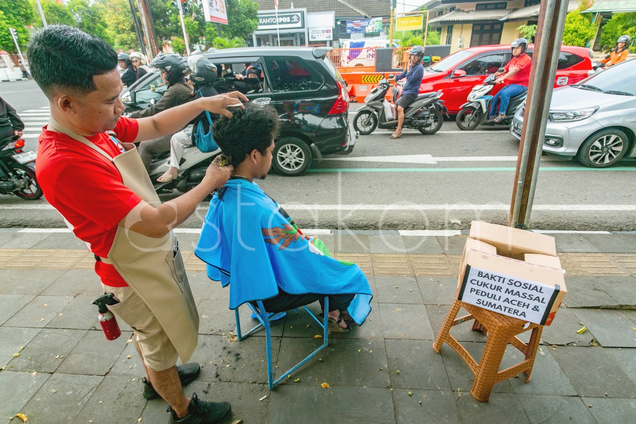 Seniman Rambut Gunungkidul laksanakan bakti sosial cukur massal dalam rangka penggalangan dana masyarakat terdampak banjir dan tanah longsor di Sumatera. Belasan juru potong rambut membuka lapak di depan alun-alun Pemda Gunungkidul minggu pagi (7/12).