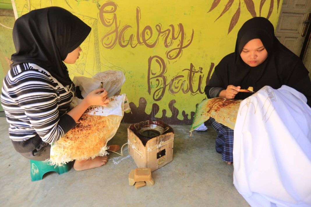 Remaja yang tergabung dalam kelompok usaha Shanumesty menyelesaikan motif batik Semarak Alek Nagari dan Rumah Gadang menggunakan malam batik dari pati sawit.