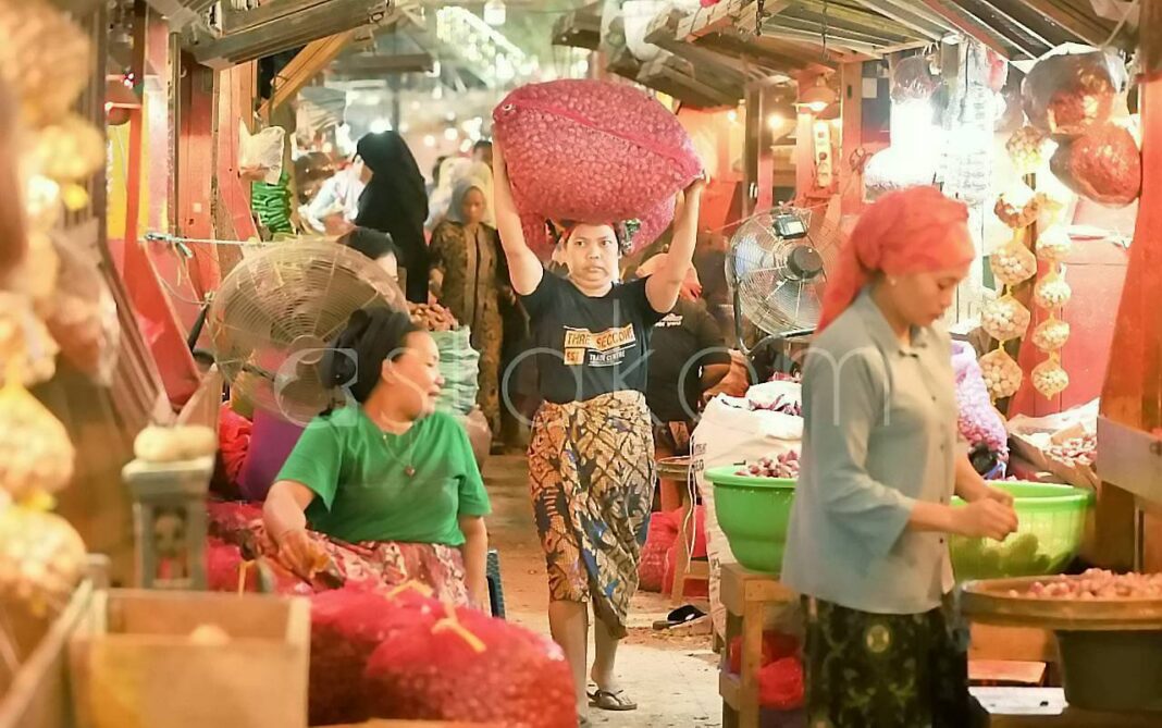Pedagang menunjukkan stok bawang dan cabai rawit di Pasar Pabean Surabaya