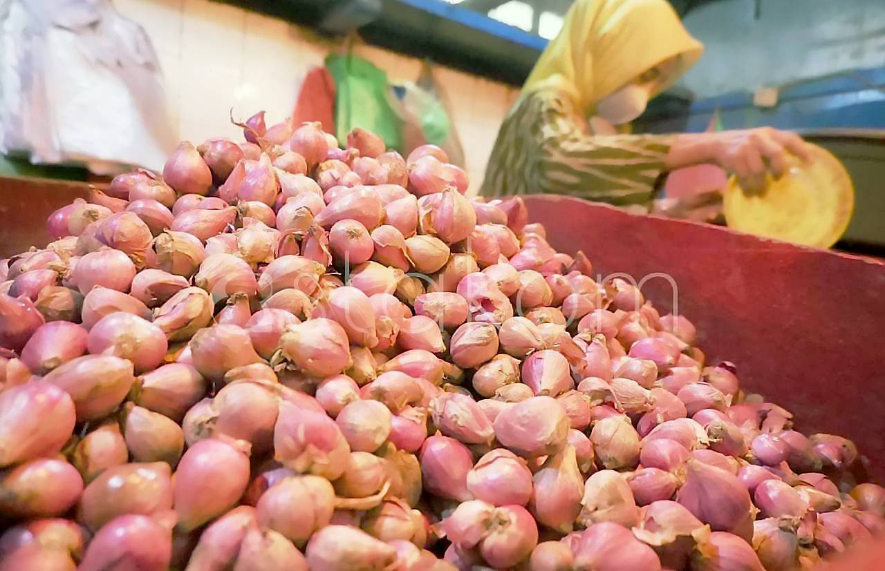 Pedagang menunjukkan stok bawang dan cabai rawit di Pasar Pabean Surabaya