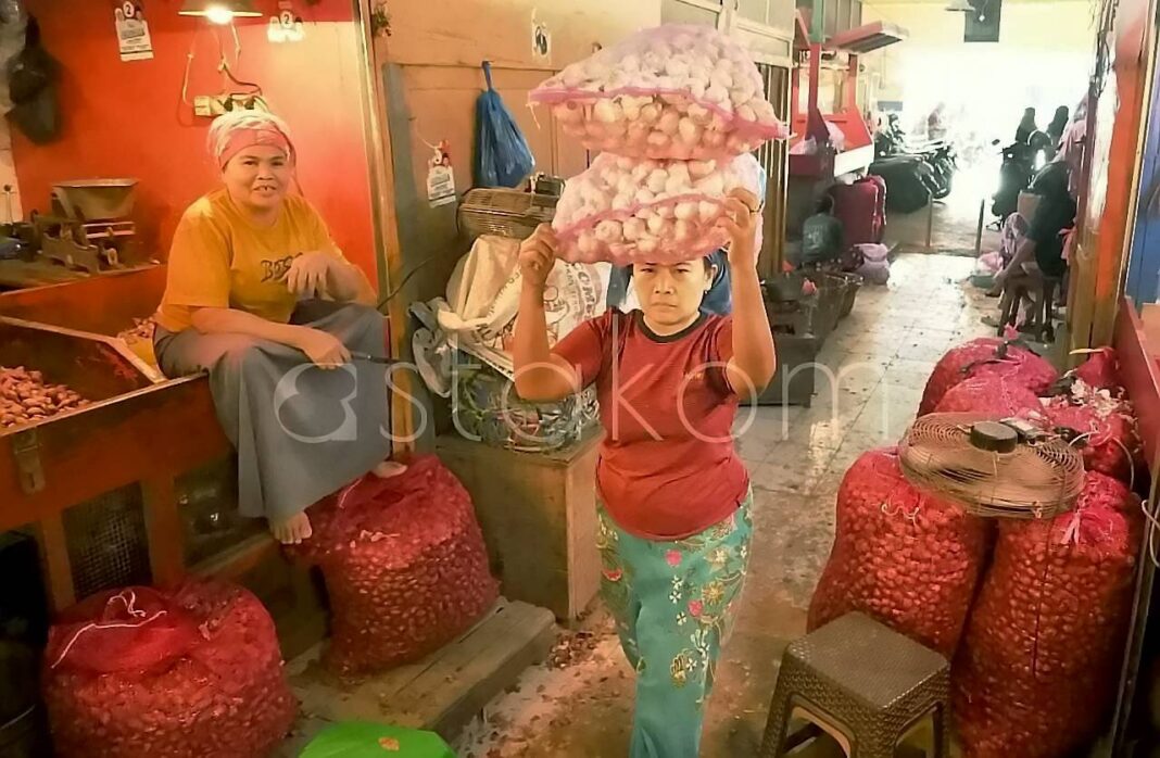 Pedagang menunjukkan stok bawang dan cabai rawit di Pasar Pabean Surabaya