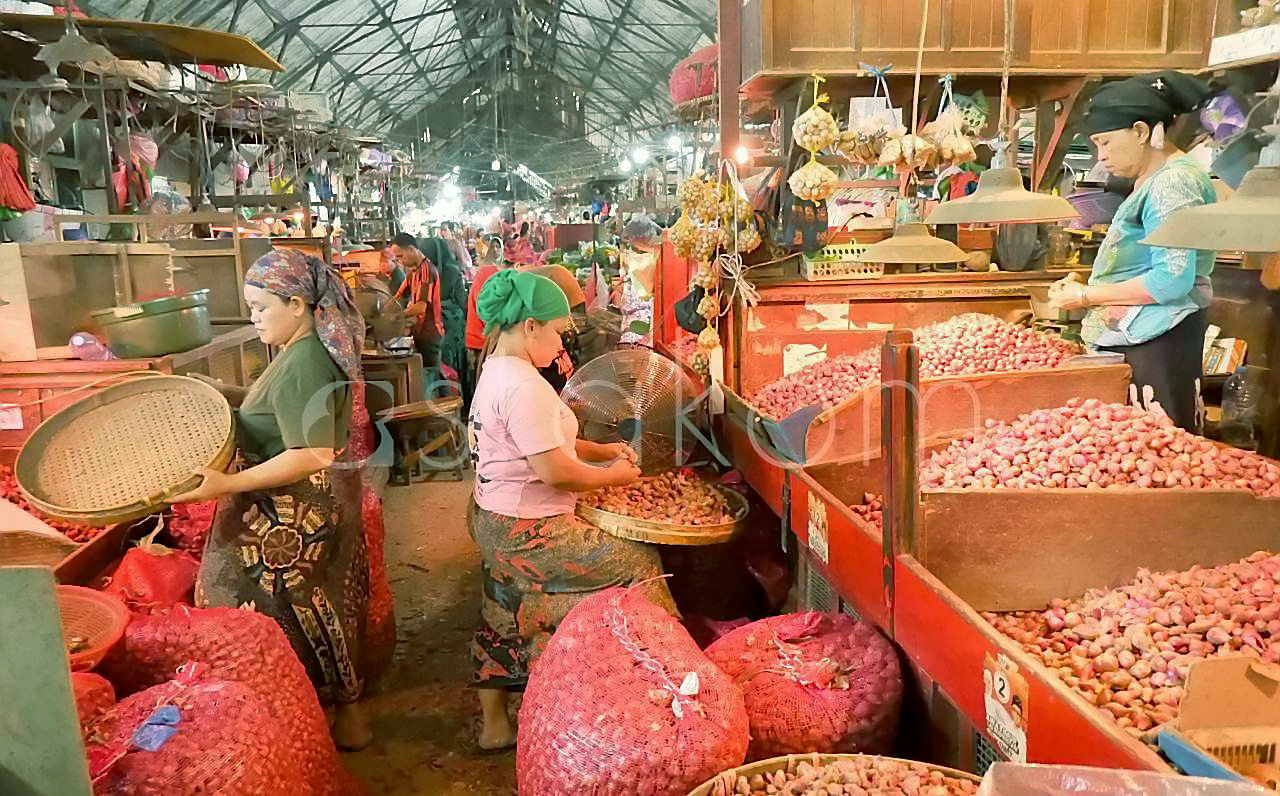 Pedagang menunjukkan stok bawang dan cabai rawit di Pasar Pabean Surabaya