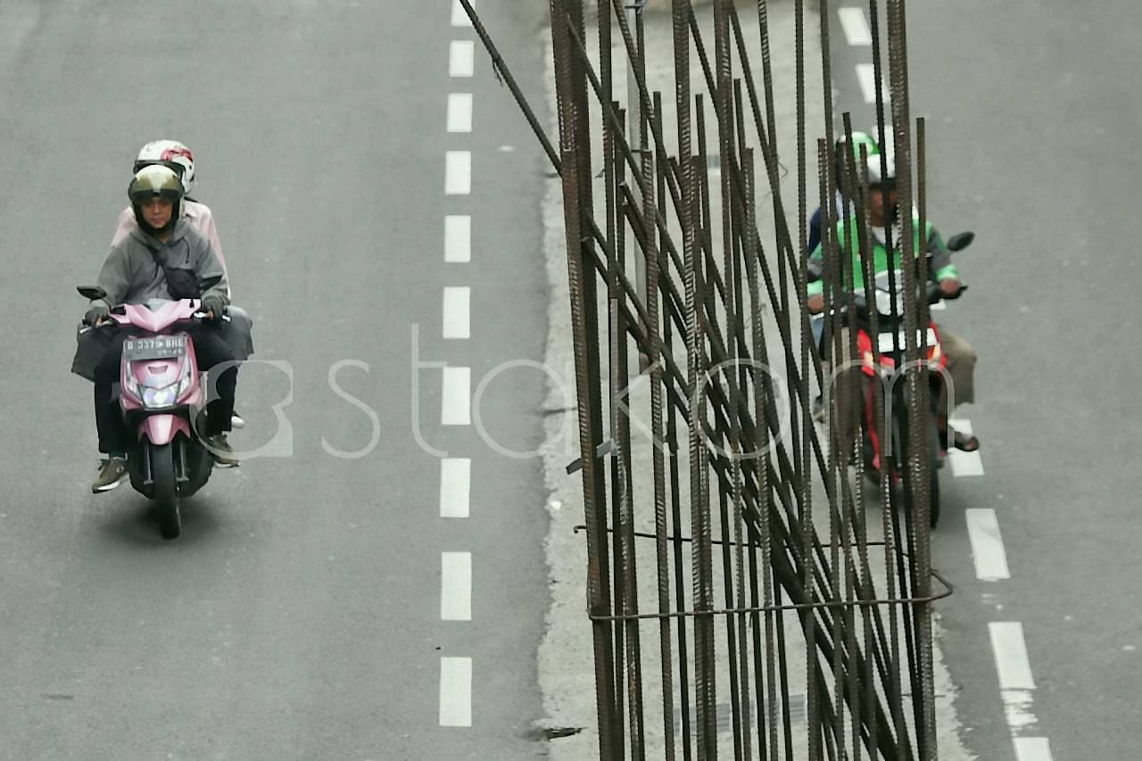 Pengendara melintas di jajaran tiang monorel yang mangkrak di Jalan HR Rasuna Said Kuningan Jakarta