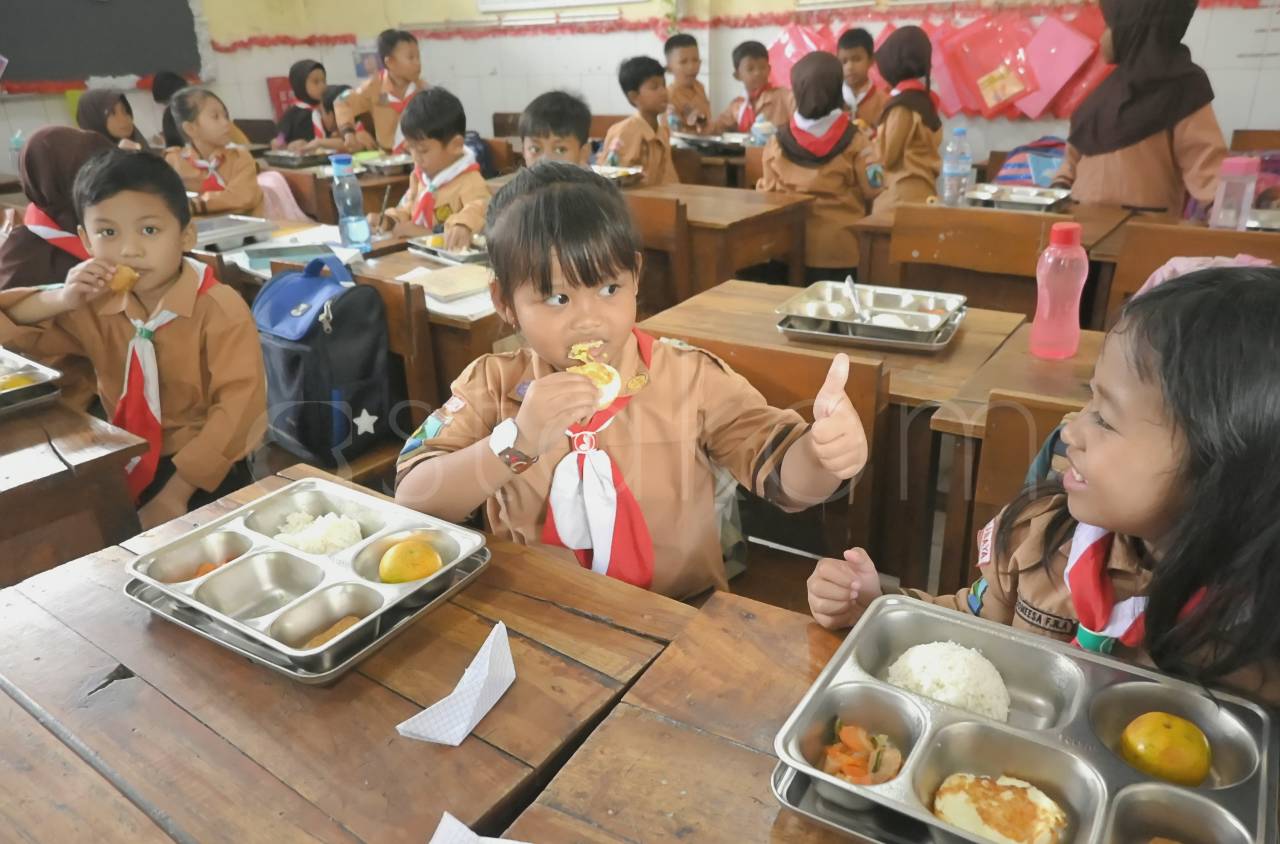 Distribusi Makan Bergizi Gratis bagi jutaan penerima manfaat di sekolah.
