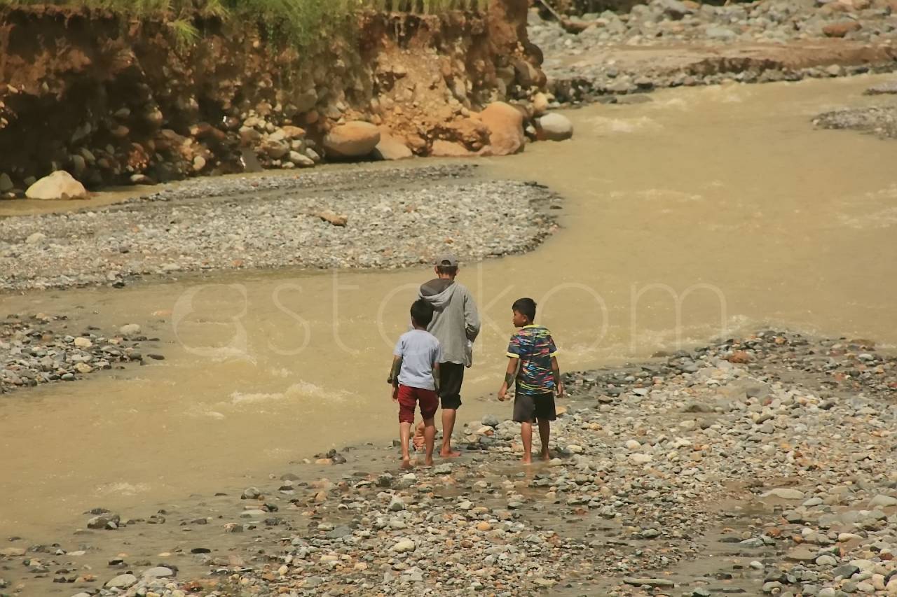 Warga Kelurahan Lambung Bukit menyeberangi sungai Batu Busuk Padang.