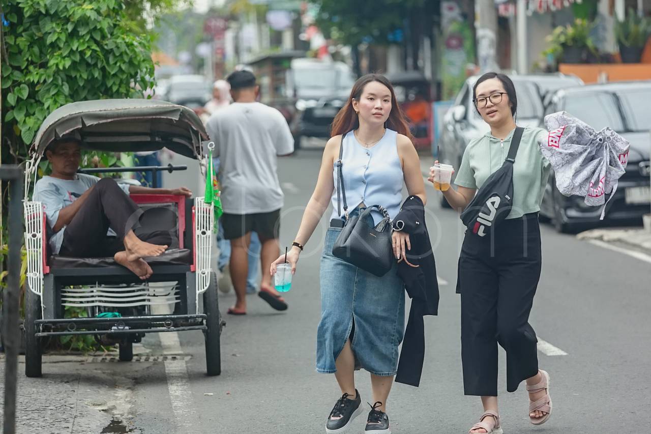 Wisatawan mancanegara berjalan di sepanjang jalan Prawirotaman Yogyakarta.